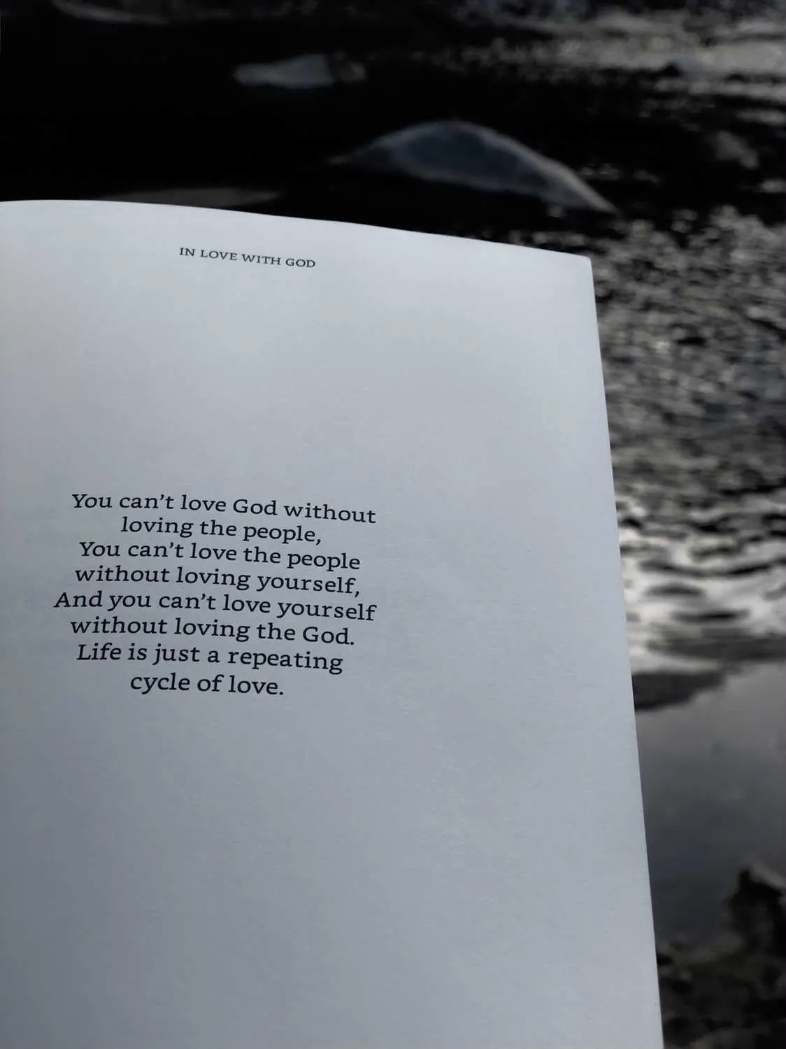 The book open over a dark stream: 'You can't love God without loving the people... Life is just a repeating cycle of love.'